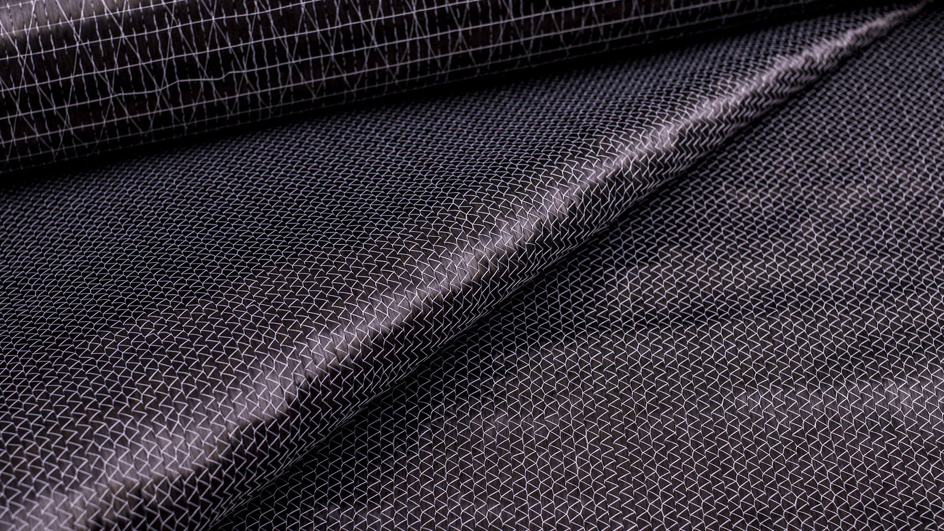 Close-up of multiaxial carbon fiber fabrics, highlighting their complex weave and high-strength design.